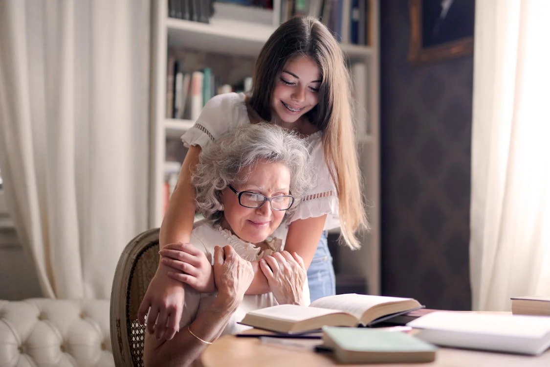 Daughter hugging her mother while she reads