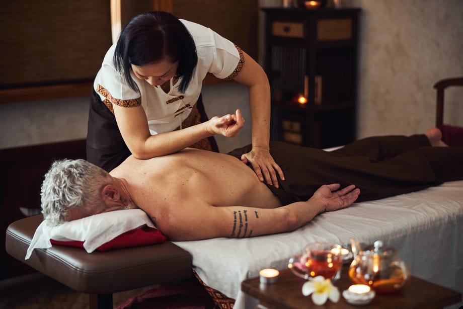 Asian-female-doing-traditional-thai-massage-for-man
